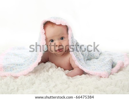 Baby lying on tummy under crocheted blanket