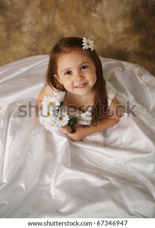  young female child wearing her mother's wedding dress which is too big