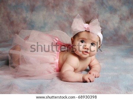 Portrait of a beautiful baby girl wearing a pink ballet tutu and pink hair bow headband