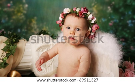 Beautiful young girl wearing angel wings and flower halo with somber expression