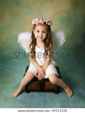 Beautiful young girl wearing angel wings and flower halo with smile happy expression
