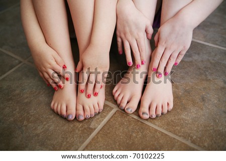Two young children girls with manicures and pedicures showing their feet and hands