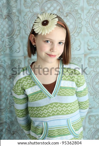 Portrait of a cute young girl wearing a flower hair band in studio