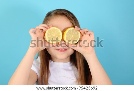 Funny Portrait of a young girl with lemon slices over her eyes