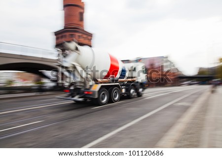 city street with a driving cement truck