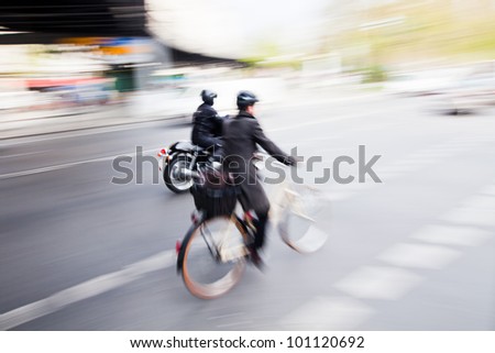 city traffic with a cyclist and a motorcyclist in motion blur