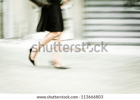 motion blur picture of a walking woman in the city