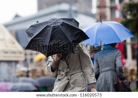 people walking with umbrellas in the rainy city