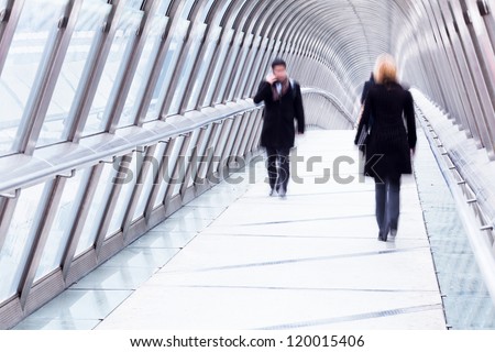 silhouette of business people walking over a pedestrian bridge in Paris, La Defense