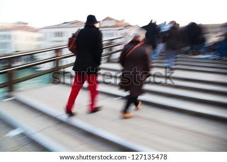 people in motion blur crossing the bridge Ponte dell Academia in Venice