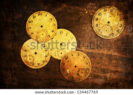 grunge textured picture of antique clock faces on wood