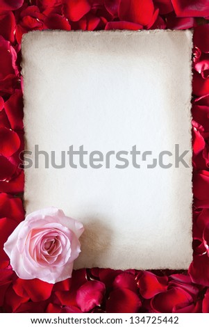 antique paper with a pink rose framed from red rose petals