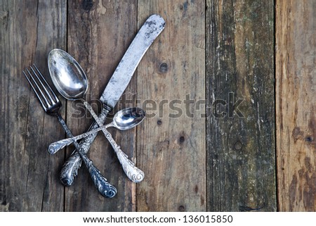 antique set of knife spoons and fork on a wooden table with space to copy