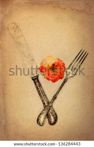 bitten apple with antique knife and fork on vintage looking old paper texture