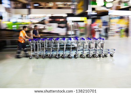 motion blur picture of worker with trolley cars at an airport