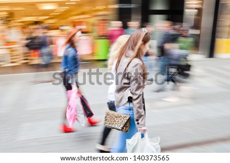 shopping women in motion blur in a shopping street of the city