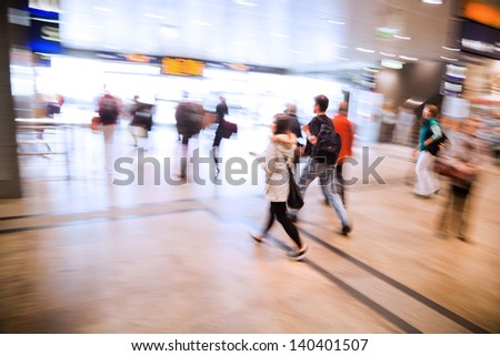 people in motion blur walking in a railway station