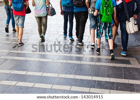 crowd of young people walking in the city