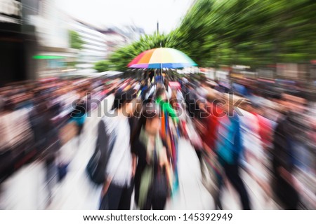 crowds of people walking in the pedestrian area of a city with zoom effect