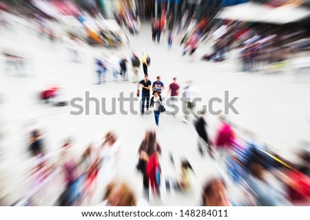 crowd of walking people on a city square with creative zoom effect