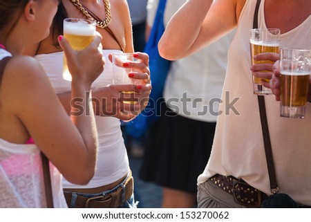 group of young people drinking beer at a summer event