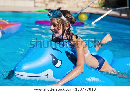 cute girl plays with a blow up dolphin