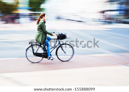 woman riding a bicycle in the city in motion blur