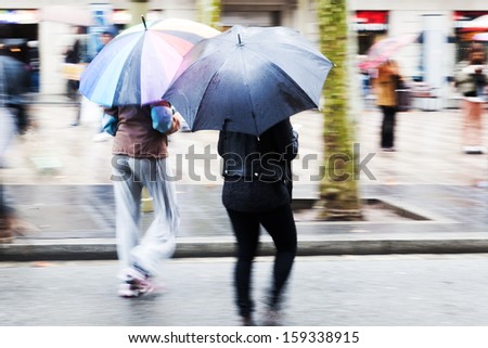 women with umbrellas walking with umbrellas in the rainy city