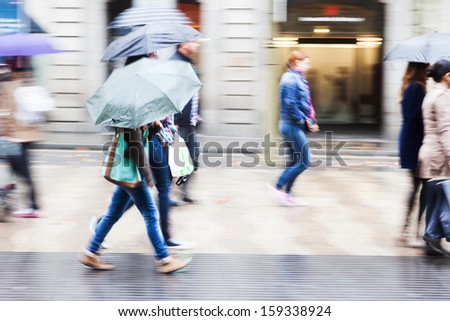 people with umbrellas walking in the rainy city