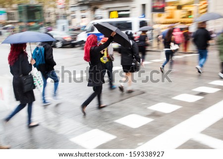 people crossing the street on a rainy day