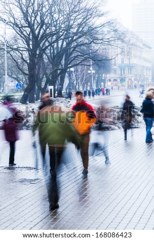 people crossing a street on a hazy winter day in motion blur