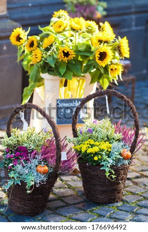 sunflowers and other autumnal flower arrangements in baskets