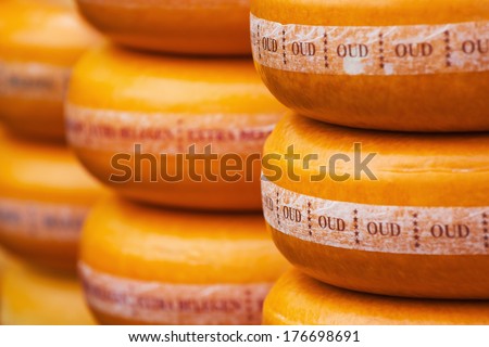 ROTTERDAM, NETHERLANDS - SEPTEMBER 21: piles of cheese wheels of old Gouda on a street market on September 21, 2013 in Rotterdam. Gouda is a worldwide spreeded and renowned cheese from the town Gouda.