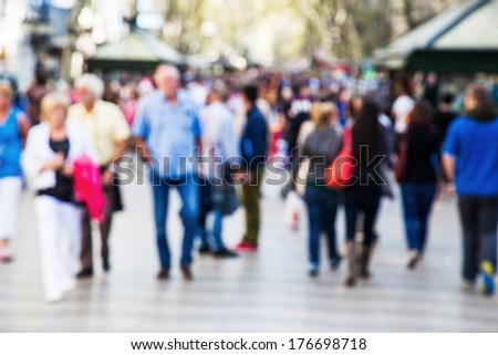 crowd of people out of focus on a strolling promenade