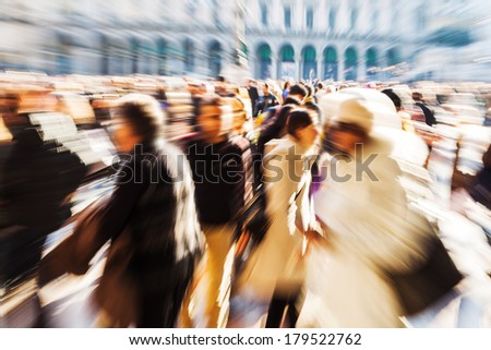 crowd of people walking on a city square in motion blur and zoom effect