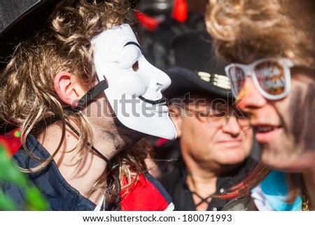 COLOGNE, GERMANY - MARCH 03: unidentified costumed man with masks in the crowd at the Rose Monday parade on March 03, 2014. The famous parade from Cologne is the German largest one.