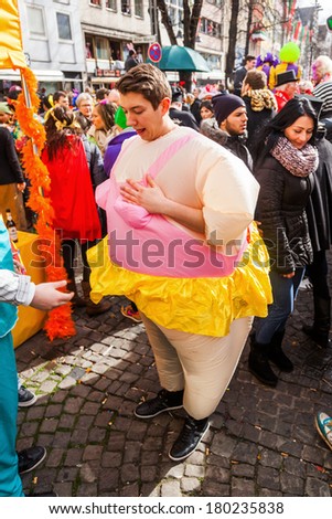 COLOGNE, GERMANY - MARCH 03: unidentified people and a man with a funny costume along the Rose Monday parade on March 03, 2014 in Cologne. The parade of Cologne is the largest one in Germany.
