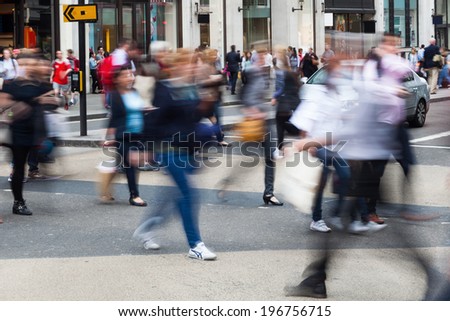 crowds of busy people crossing the street in the city of London