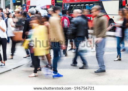crowds of busy people crossing the street in the city of London