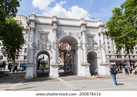 LONDON - MAY 19: Marble Arch with unidentified people on May 19, 2014 in London. It is a 19th century white marble faced triumphal arch and London landmark, which was designed by John Nash in 1827