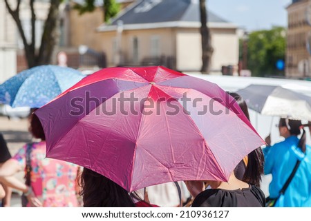 crowd of people with sun umbrellas