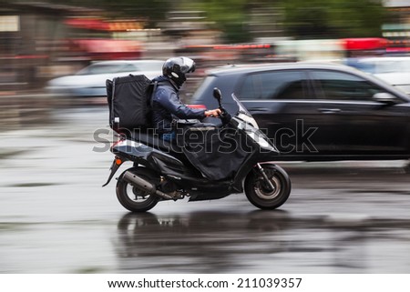 riding scooter in the rainy city