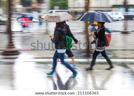 city people with rain umbrellas walking in the rainy city