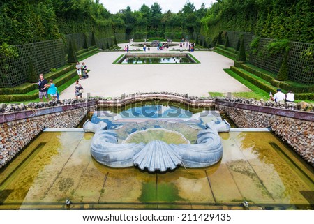 VERSAILLES, FRANCE - AUGUST 05: fountain in in the gardens of the Palace of Versailles with unidentified people on August 05, 2014 in Versailles. The palace complexes is protected by UNESCO