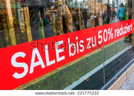 letters -sale up to 50 percent- on a red strip on a shop window