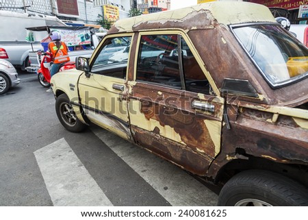 BANGKOK - DECEMBER 12: street scene in Chinatown with a rusted car on December 12, 2014 in Bangkok. Chinese began settling in the Bangkoks Chinatown circa 1800s, it is a famous tourist attraction