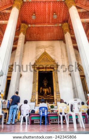 BANGKOK, THAILAND - DECEMBER 12, 2014: unidentified prayers at Wat Suthat, a royal temple of first grade, 1 of 10 such temples in Bangkok -23 in Thailand-, construction began by King Rama I in 1807