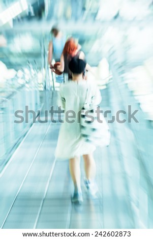 woman on an escalator at the airport with creative zoom effect