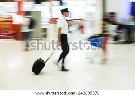 motion blur picture of a pilot with a trolley at the airport