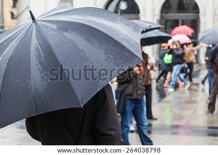 on a rainy day with rain umbrella in the city